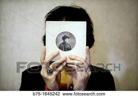 Mujer joven con retrato antiguo en las manos tapandole la cara, Young woman with old picture in her hands covering her face, View Large Photo Image Stock Image - Mujer joven con retrato antiguo en las manos tapandole la cara, Young woman with old picture in her hands covering her face,. Fotosearch
