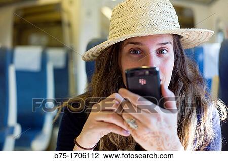 Stock Image - mujer joven con sombrero y telefono movil en la mano, young woman with hat and mobile phone in hand,. Fotosearch