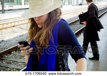 mujer joven mirando el telefono movil en la estacion de tren de Girona, Catalua, Espaa, Young woman looking at mobile phone on the train station in Girona, Catalonia, Spain View Large Photo Image Stock Image - mujer joven mirando el telefono movil en la estacion de tren de Girona, Catalua, Espaa, Young woman looking at mobile phone on the train station in Girona, Catalonia, Spain. Fotosearch