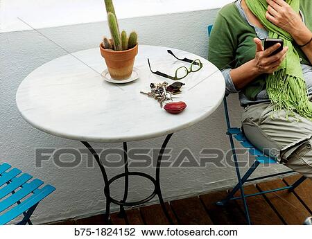 Stock Image - Mujer media edad en terraza relajada mirando telefono movil Middle aged woman relaxing on the terrace looking mobile phone. Fotosearch