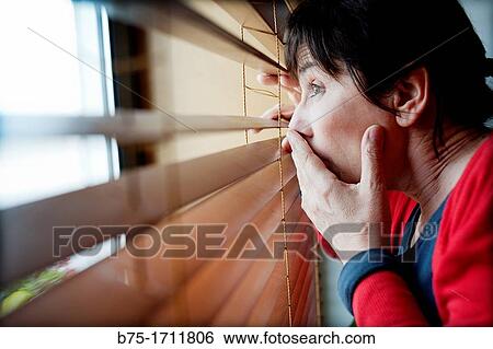 Stock Photograph - mujer mirando a traves de la ventana, woman looking through the window. Fotosearch