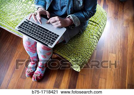 mujer sentada en una chaise longue trabajando con un ordenador portatil, woman sitting on a chaise longue working with a laptop View Large Photo Image Stock Image - mujer sentada en una chaise longue trabajando con un ordenador portatil, woman sitting on a chaise longue working with a laptop. Fotosearch