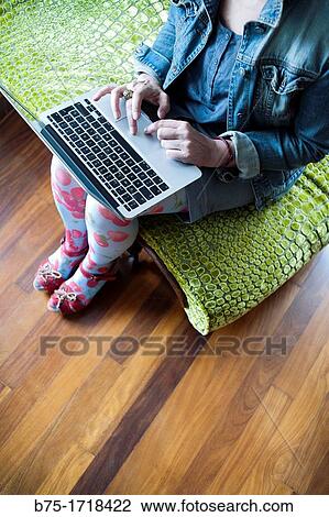 mujer sentada en una chaise longue trabajando con un ordenador portatil, woman sitting on a chaise longue working with a laptop View Large Photo Image Stock Image - mujer sentada en una chaise longue trabajando con un ordenador portatil, woman sitting on a chaise longue working with a laptop. Fotosearch