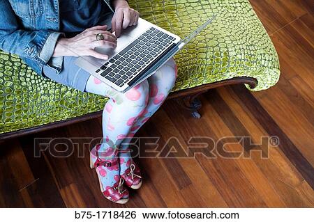 mujer sentada en una chaise longue trabajando con un ordenador portatil, woman sitting on a chaise longue working with a laptop, View Large Photo Image Stock Photograph - mujer sentada en una chaise longue trabajando con un ordenador portatil, woman sitting on a chaise longue working with a laptop,. Fotosearch