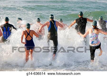 Mullet Man Triathlon, surf, swim, competitors, run, jump, splash. Gulf of Mexico Florabama. Alabama. USA. View Large Photo Image Picture - Mullet Man Triathlon, surf, swim, competitors, run, jump, splash. Gulf of Mexico Florabama. Alabama. USA.. Fotosearch