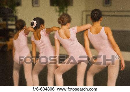 Multi-ethnic group of ballet dancers wearing pink leotards practes ballet position in front of mirror in ballet class. View Large Photo Image Stock Photograph - Multi-ethnic group of ballet dancers wearing pink leotards practes ballet position in front of mirror in ballet class.. Fotosearch