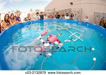 Stock Photo - Multiracial middle school students in Mission Viejo, CA, test the remote operated submarine vehicles (ROV) they built in their robotics classroom in an outdoor pool.. Fotosearch