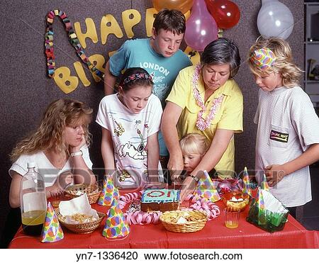 Mum cutting the cake at a family birthday party View Large Photo Image Stock Image - Mum cutting the cake at a family birthday party. Fotosearch