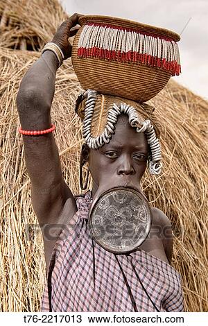 Mursi woman with lip plate in the Lower Omo Valley of Ethiopia. The Mursi girls have a fold cut in their lower lip as they enter womanhood, where a pulley is inserted, which then stretches the lip until larger plates can be put in. View Large Photo Image Stock Image - Mursi woman with lip plate in the Lower Omo Valley of Ethiopia. The Mursi girls have a fold cut in their lower lip as they enter womanhood, where a pulley is inserted, which then stretches the lip until larger plates can be put in.. Fotosearch