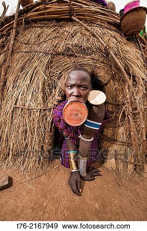 Mursi woman with lip plate in the Lower Omo Valley of Ethiopia. The Mursi girls have a fold cut in their lower lip as they enter womanhood, where a pulley is inserted, which then stretches the lip until larger plates can be put in. View Large Photo Image Stock Photo - Mursi woman with lip plate in the Lower Omo Valley of Ethiopia. The Mursi girls have a fold cut in their lower lip as they enter womanhood, where a pulley is inserted, which then stretches the lip until larger plates can be put in.. Fotosearch