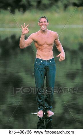 Stock Photograph - Muscular young man standing on water. Fotosearch
