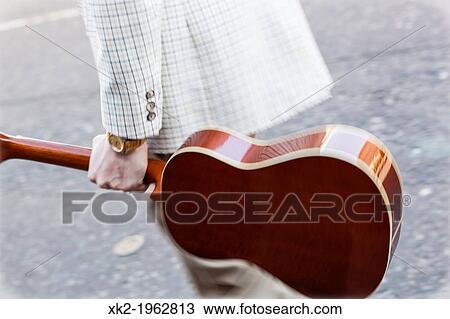 Musician carrying a spanish guitar on the street View Large Photo Image Stock Image - Musician carrying a spanish guitar on the street. Fotosearch