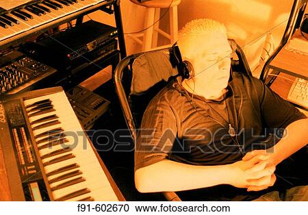 Musician listening to music on headphones View Large Photo Image Stock Image - Musician listening to music on headphones. Fotosearch