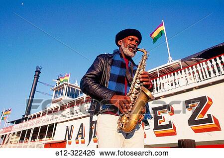 Stock Photograph - Musician playing in front of steamboat? Natchez? on Mississippi river. New Orleans. Louisiana, USA. Fotosearch