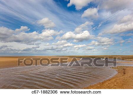 Stock Photograph - Mussels fisherman returning on River Stiffkey in Blakeney Harbour, Norfolk, September. Fotosearch