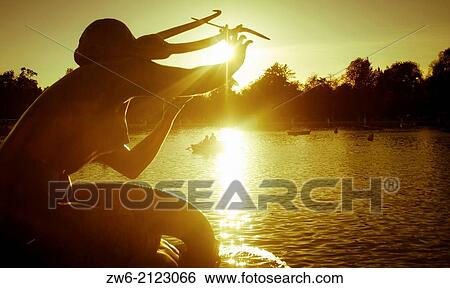 Mysterious statue holding its hand toward the sun, Parque del Retiro, Madrid, Spain View Large Photo Image Stock Photograph - Mysterious statue holding its hand toward the sun, Parque del Retiro, Madrid, Spain. Fotosearch