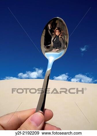 mysterious woman reflected in teaspoon held by male hand in sand dunes View Large Photo Image Stock Photo - mysterious woman reflected in teaspoon held by male hand in sand dunes. Fotosearch