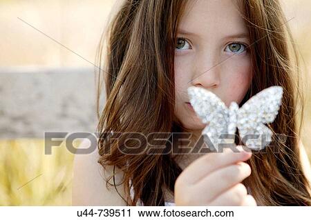 Stock Image - Mystery girl showing her butterfly. Fotosearch
