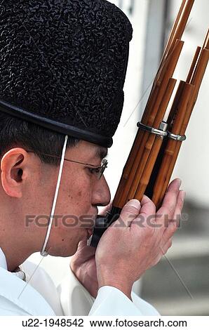 Stock Image - Naha, Okinawa, Japan, Shinto priest playing music during the burning Shimenawa rope ceremony at Naminoue Shrine. Fotosearch