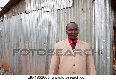 Stock Photography - Nairobi Kenya Africa minister man portait smiling near Salama at metal building church in Ngokomi. Fotosearch