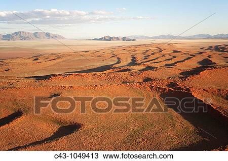 Namibia - Aerial view of grass-grown sand dunes and isolated mountain ridges at the edge of the Namib Desert In March during the rainy season with a delicate carpet of green desert grass NamibRand Nature Reserve, Namibia View Large Photo Image Stock Image - Namibia - Aerial view of grass-grown sand dunes and isolated mountain ridges at the edge of the Namib Desert In March during the rainy season with a delicate carpet of green desert grass NamibRand Nature Reserve, Namibia. Fotosearch