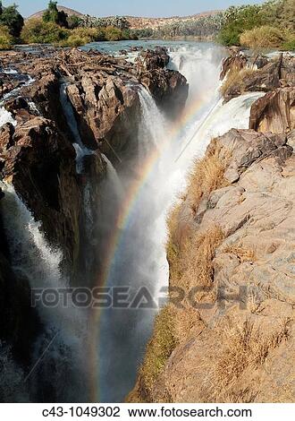 Namibia - At the beautiful Epupa Falls the Kunene River border river between Namibia and Angola drops in a series of cascades into a 60m deep gorge Kaokoland, Kunene region, Namibia View Large Photo Image Stock Image - Namibia - At the beautiful Epupa Falls the Kunene River border river between Namibia and Angola drops in a series of cascades into a 60m deep gorge Kaokoland, Kunene region, Namibia. Fotosearch