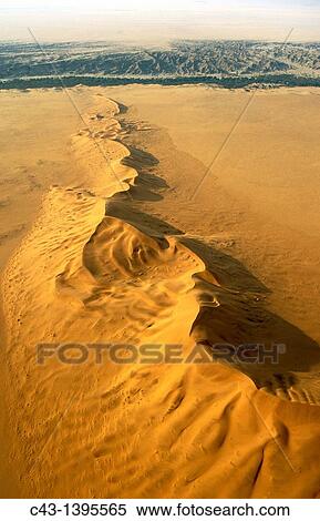 Namibia - The green belt of the dry Kuiseb riverbed in the background is forming the northern boundary of the expanse of dunes of the southern Namib Desert Aerial view Namib-Naukluft Park, Namibia View Large Photo Image Stock Photography - Namibia - The green belt of the dry Kuiseb riverbed in the background is forming the northern boundary of the expanse of dunes of the southern Namib Desert Aerial view Namib-Naukluft Park, Namibia. Fotosearch
