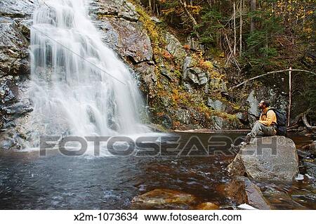 Picture - Nancy Brook Scenic Area - A hiker enjoys the view of Nancy Cascade located along the Nancy Pond Trail in the White Mountains, New Hampshire USA. Fotosearch