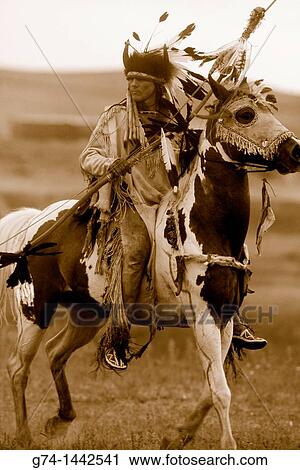 Stock Image - Native American Riding on Horseback Re-enactment Model Released. Fotosearch