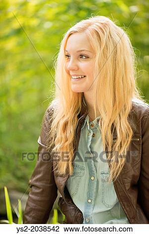 Nature scene with one young attractive woman leaning against a tree in a park. View Large Photo Image Stock Image - Nature scene with one young attractive woman leaning against a tree in a park.. Fotosearch