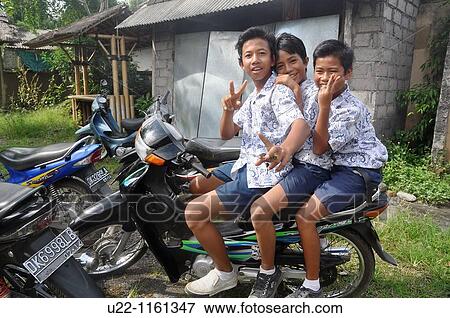 Stock Photo - near Denpasar (Bali, Indonesia): three kids on a motor-bike. Fotosearch