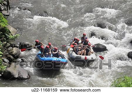 Stock Photo - near Ubud (Bali, Indonesia): Taiwanese tourists rafting along the Ayung river, by the Sayan paddies. Fotosearch