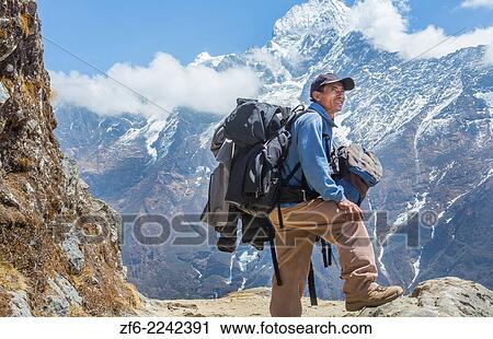 Nepal. Mountain Trekking guide poses with his bags and the Himalayan mountains in the distance. Solukhumbu, remote, Mt Everest, Himalayas 50. View Large Photo Image Stock Image - Nepal. Mountain Trekking guide poses with his bags and the Himalayan mountains in the distance. Solukhumbu, remote, Mt Everest, Himalayas 50.. Fotosearch
