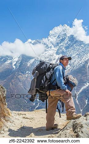 Nepal. Mountain Trekking guide poses with his bags and the Himalayan mountains in the distance. Solukhumbu, remote, Mt Everest, Himalayas 50. View Large Photo Image Stock Image - Nepal. Mountain Trekking guide poses with his bags and the Himalayan mountains in the distance. Solukhumbu, remote, Mt Everest, Himalayas 50.. Fotosearch