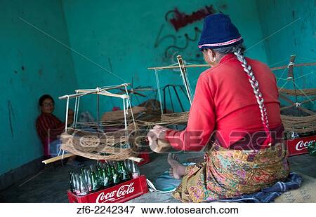 Stock Photo - Nepal. Nepali weaving woman, posing and weaving threads for carpets. Nayapati, Eastern Kathmandu. 43.. Fotosearch
