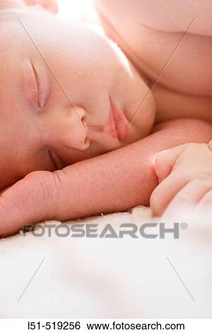Stock Photograph - New born baby sleeping in the sun.. Fotosearch