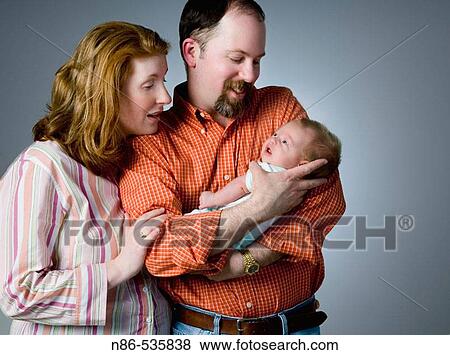 Stock Photo - New parents looking at their child. Fotosearch