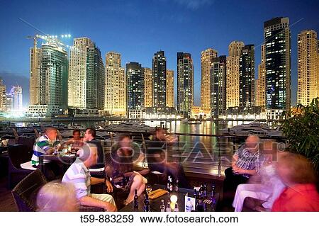 New Quarter Dubai Marina at dusk with yachting port and visitors at the restaurant of yachting club, Dubai, United Arabian Emirates View Large Photo Image Stock Photo - New Quarter Dubai Marina at dusk with yachting port and visitors at the restaurant of yachting club, Dubai, United Arabian Emirates. Fotosearch