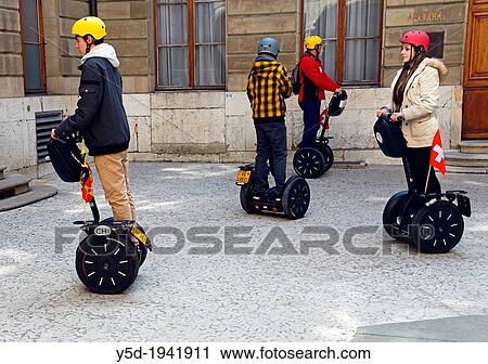 new way of touristic sightseeing on Segway, two-wheeled, self-balancing electric vehicle invented by Dean Kamen, Geneva, Switzerland, here the group of tourists in courtyard of townhouse. View Large Photo Image Stock Image - new way of touristic sightseeing on Segway, two-wheeled, self-balancing electric vehicle invented by Dean Kamen, Geneva, Switzerland, here the group of tourists in courtyard of townhouse.. Fotosearch