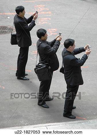 Stock Image - New York City, Chinese tourists by the Federal Hall, Wall Street, Financial District, Downtown Manhattan. Fotosearch