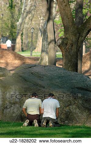 Stock Image - New York City, Muslim men praying at Central Park, Manhattan. Fotosearch