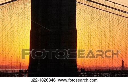 New York City, the Liberty Statue seen in the distance, at dusk, through the Manhattan Bridge View Large Photo Image Stock Photograph - New York City, the Liberty Statue seen in the distance, at dusk, through the Manhattan Bridge. Fotosearch