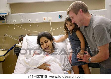 Stock Photo - Newborn baby with family in hospital. Fotosearch