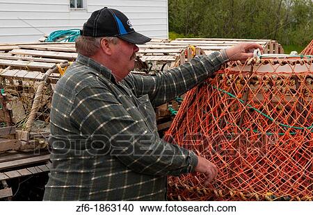 Stock Image - Newfoundland Canada Port de Graves harbor working fisherman with crab pots. Fotosearch