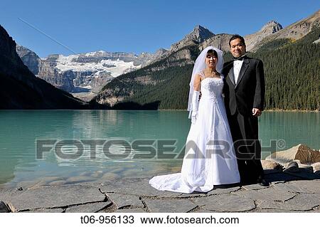 Newly wed couple at a photo session on lake Louise, Banff National Park, Rocky Mountains, Alberta, Canada View Large Photo Image Stock Image - Newly wed couple at a photo session on lake Louise, Banff National Park, Rocky Mountains, Alberta, Canada. Fotosearch
