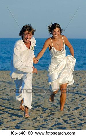 Newly young married couple running on the beach. View Large Photo Image Stock Image - Newly young married couple running on the beach.. Fotosearch