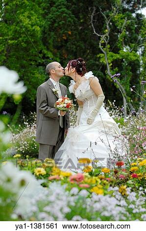 Stock Image - Newlyweds couple kissing in park, France. Fotosearch