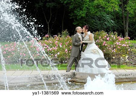 Stock Photo - Newlyweds couple kissing in park, France. Fotosearch