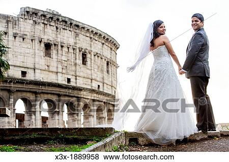 Newlyweds in front of the roman Colosseum in Rome Italy View Large Photo Image Stock Photo - Newlyweds in front of the roman Colosseum in Rome Italy. Fotosearch