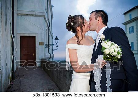 Stock Image - Newlyweds kissing at night. Fotosearch
